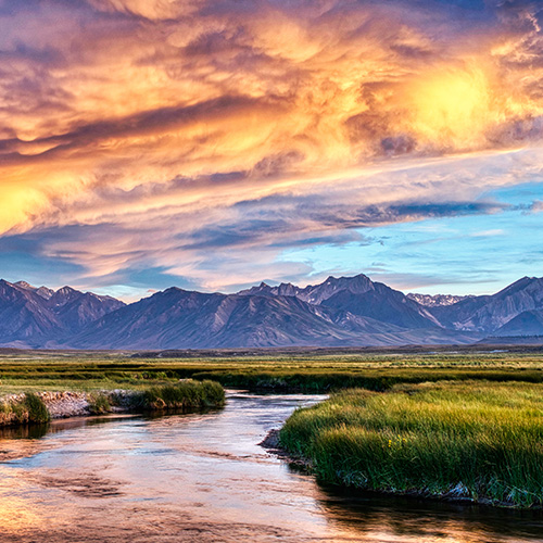 Beautiful orange sunset over a meadow and river in the Sierra Nevada valley