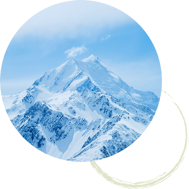 Jagged snowcapped mountains with a blue sky and soft clouds