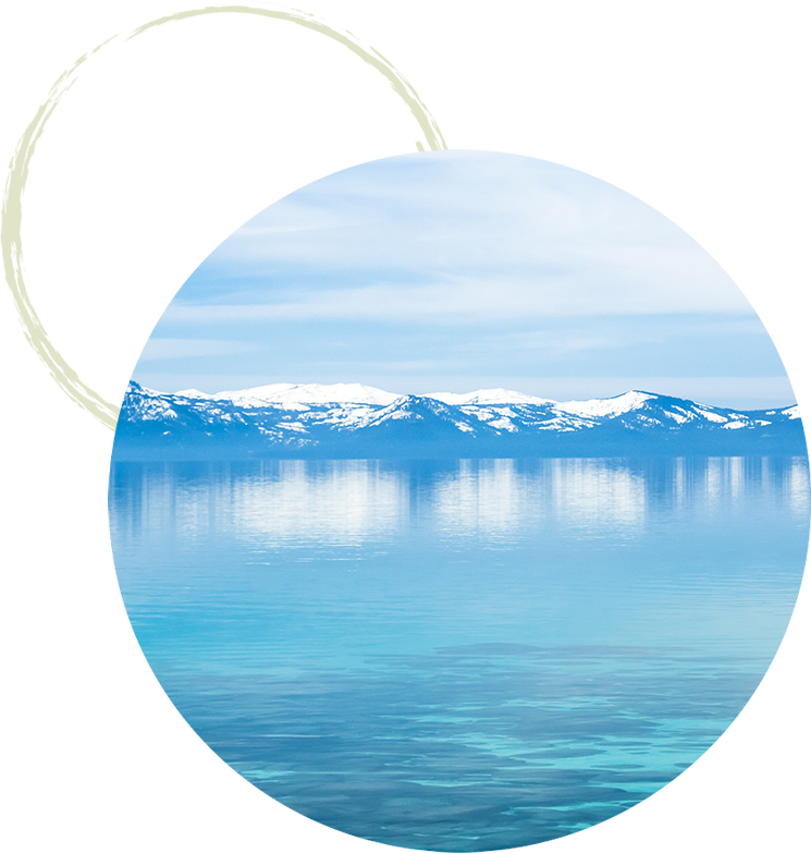 Peaceful blue water in Lake Tahoe with snowy mountains
